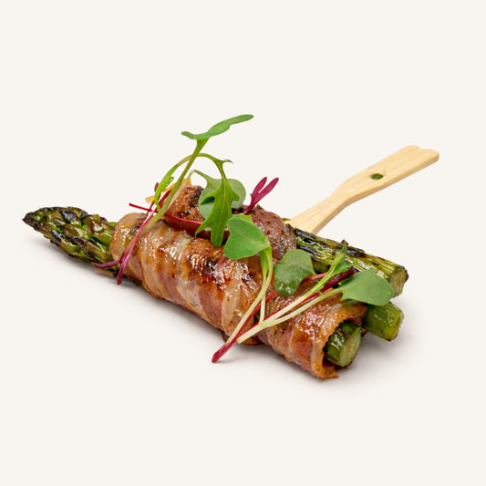 Asparagus wrapped in bacon with herbs on a white background